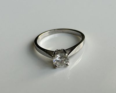 une image d'une bague en diamant sur une surface blanche