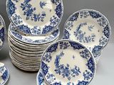 a lot of blue and white plates and bowls on the table