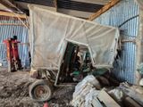 un tracteur qui est à l'arrêt dans la terre, près d'un bâtiment