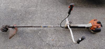 an image of a string trimmer laying on the ground
