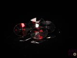 deux paires de boucles d'oreilles en cristal rouge et blanc posées sur un fond noir