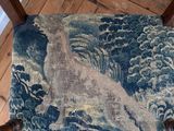 a chair that has a blue and white tapestry on it