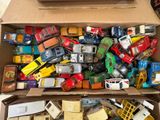 a cardboard box full of toy cars and trucks