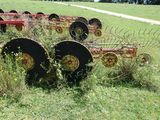 a row of old farm implements in the middle of a field