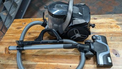 un aspirateur posé sur une table à côté d'un bidon