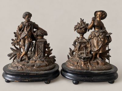 pair of antique bronze figurines of a woman and a man