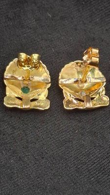 three pieces of gold jewelry on a black cloth