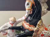 a figurine of a horse and a doll on a table