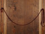 an old wooden frame with a rope hanging from it ' s side