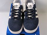a pair of blue and white adidas sneakers on a blue box