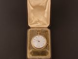 a gold case with a white clock inside of it