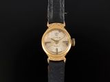 une montre-bracelet plaquée or avec un bracelet en cuir noir