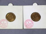 two coins are sitting on top of each other on a table