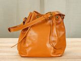 an orange purse sitting on top of a wooden table