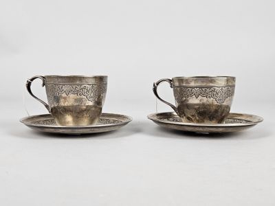a pair of silver cups and saucers on a saucer
