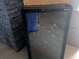 a small refrigerator sitting in front of a stone wall