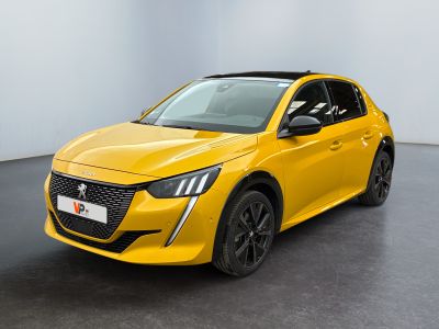 Une voiture jaune est garée dans une pièce blanche au sol noir.