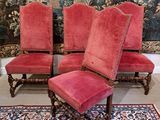two red chairs and a red rug in front of a tapestry