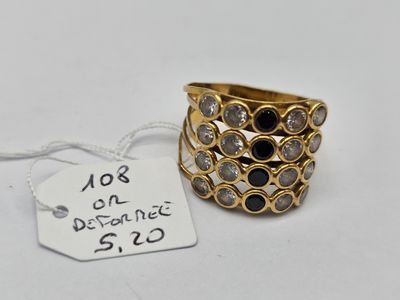 gros plan d'une bague sur une surface blanche avec une étiquette de prix