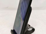 a close up of a cell phone on a stand on a table