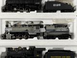 three train engines in a display case on a table