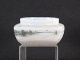 a glass vase with a picture on it sitting on a stand
