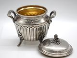 an antique silver bowl with a lid and a lid on a white surface