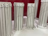 three silver vases sitting on a table in front of a red wall