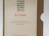 french book le coran, with arabic writing, on a white background