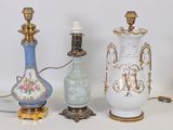 three vases and a lamp on a white table
