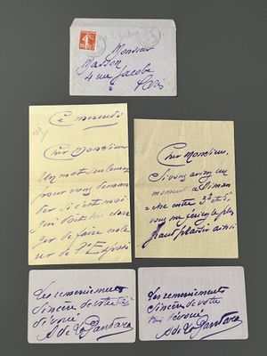 quatre feuilles de papier portant des inscriptions manuscrites, posées sur une table