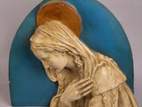 statue d'une femme en prière devant une arche bleue