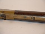 an old gun is laying on a table with a white background