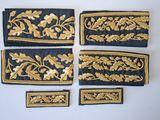 quatre morceaux de tissu brodé noir et or, ornés de motifs en feuille d'or