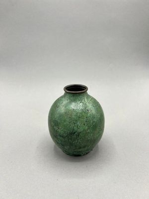 a small green vase sitting on a white surface