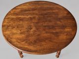 an old wooden table with turned legs and a round top