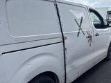 a white van that has been vandalized and is parked in a lot