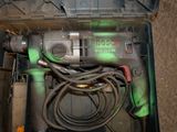 a drill in a tool box with a cord in it