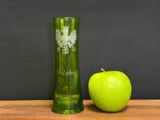 a green apple next to a green glass on a table