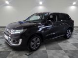 un 4x4 noir garé sur un sol en damier dans un garage
