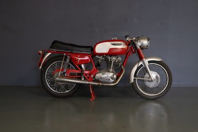une moto rouge et blanche garée dans un garage