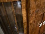 a wooden cabinet with a glass door in the corner