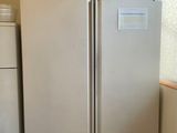 two refrigerators that are in a kitchen near a window