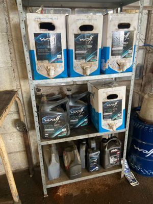plusieurs cartons d'huile moteur posés sur une étagère dans un garage