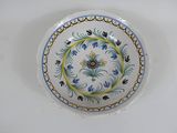 une assiette blanche ornée de motifs bleus et jaunes