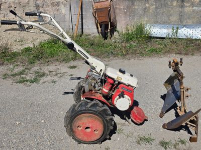 un petit tracteur équipé d'une charrue