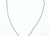 a gold necklace with a coin and a chain on a white background