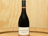 une bouteille de vin posée sur un tonneau en bois
