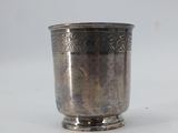 an antique silver cup with a floral design on the rim