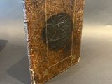 an old book sitting on top of a table next to a vase